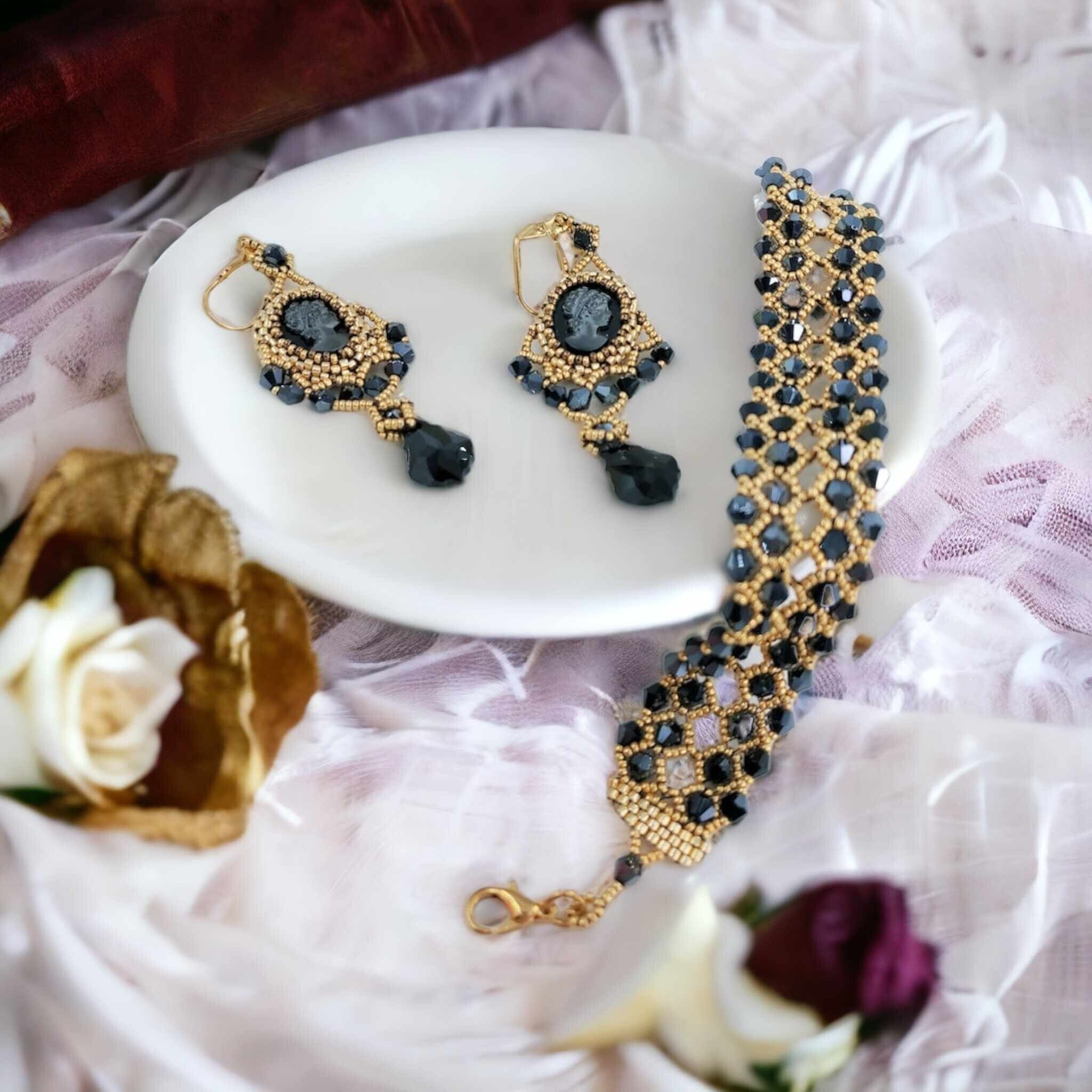 Gold and black Swarovski beaded bracelet with matching cameo earrings on white dish