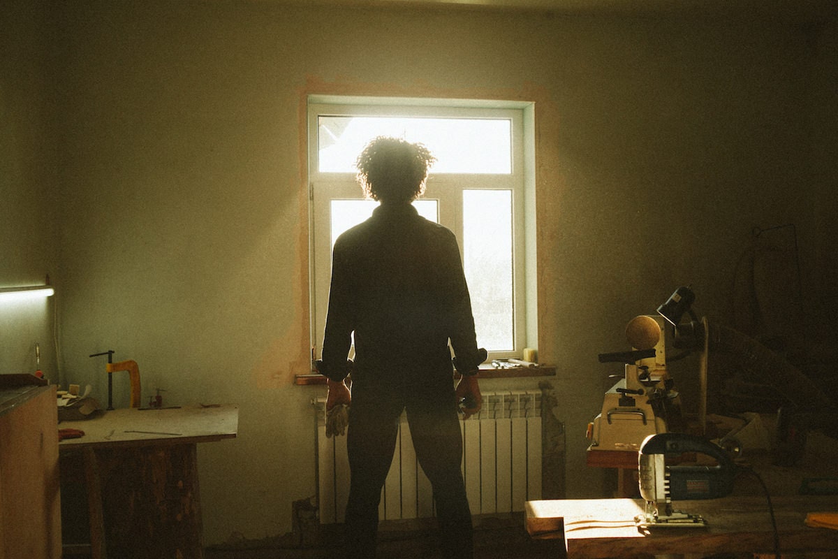 Kirill standing in his studio, looking towards the sunny window