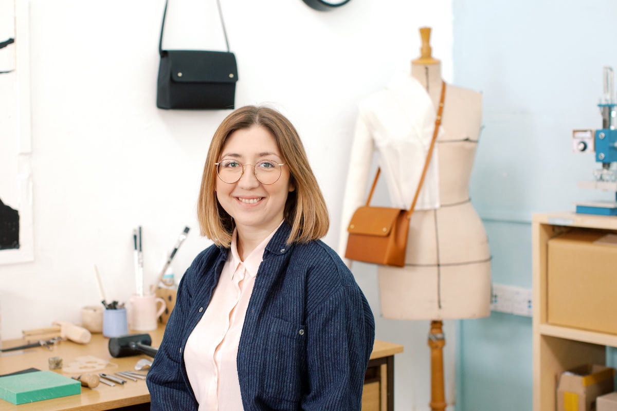Portrait of Klés accessories designer Jessica Gomez seated at her desk in her Bristol studio.
