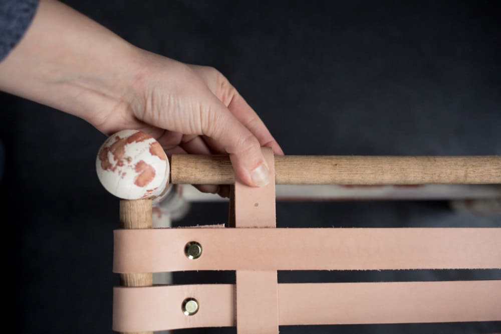 Close-up shot of leather strap attached to adjacent edge of stool