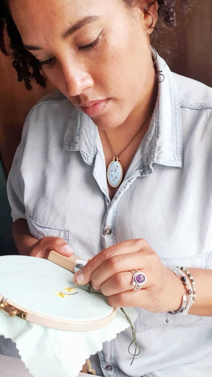 Natalie works on stitching an embroidery hoop.