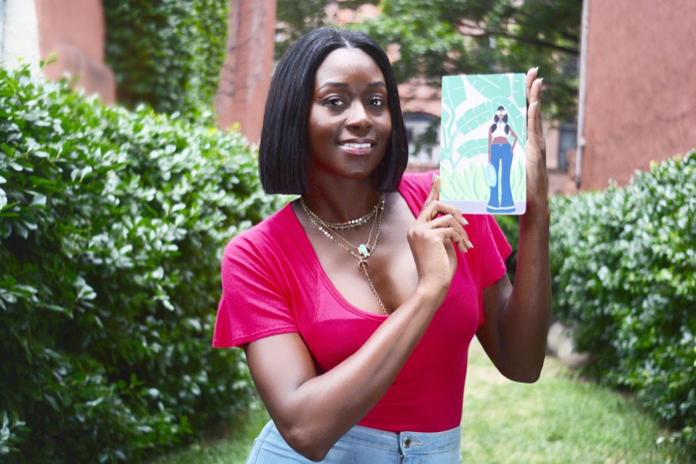 Karina holds up one of her illustrations