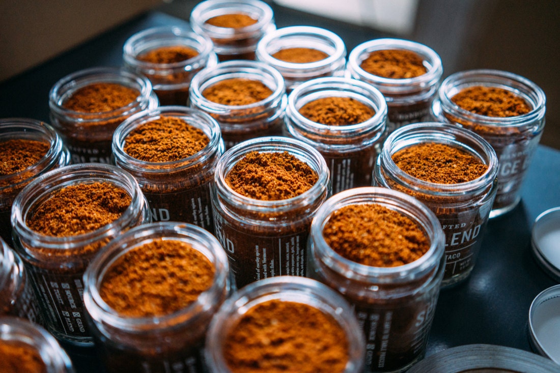 A finished batch of southwestern taco seasoning measured into jars and ready to be sealed