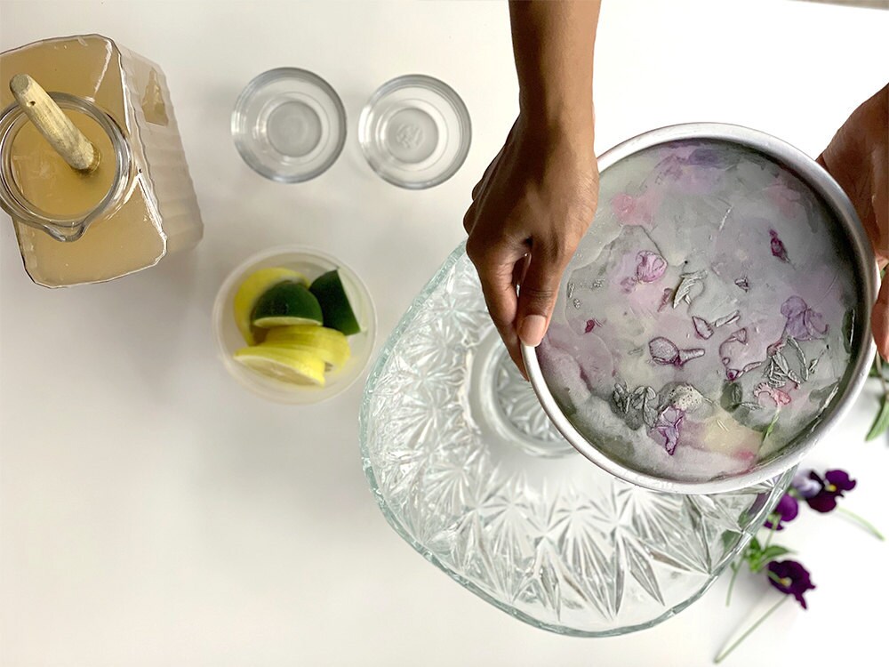 Aravis reinserts the ice block in the pan with the decorations facing up so that she can re-freeze for another 8 hours.