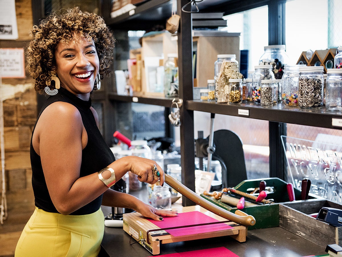 Etsy Trend Expert and Making It judge Dayna Isom Johnson smiles as she cuts paper