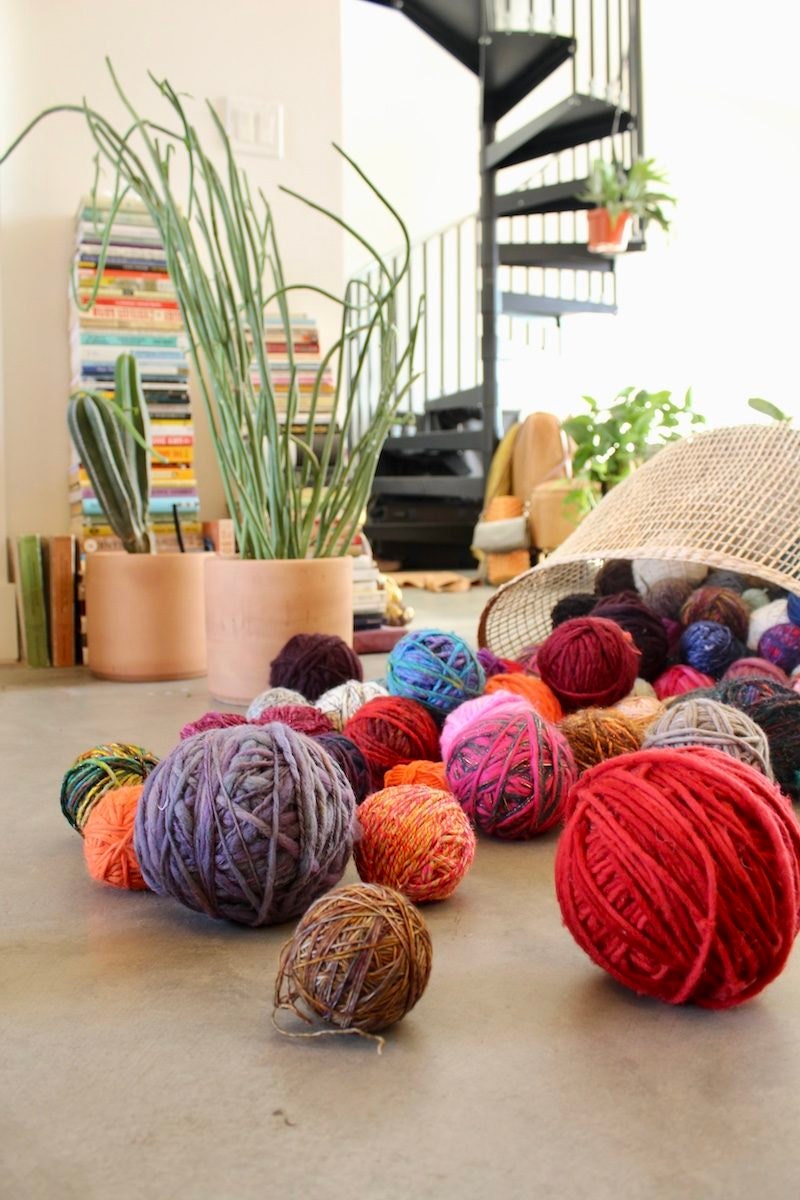 Colorful yarn spilling out of a bin in Chasten's home