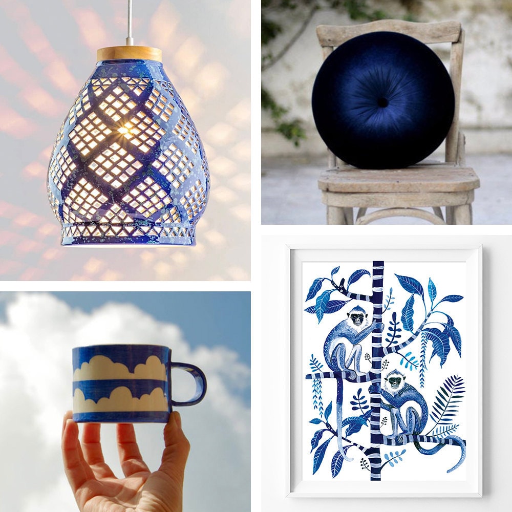 A collage of sapphire-colored items for the home, including a pendant light, a velvet pillow, a monkey art print, and a blue mug with clouds on it