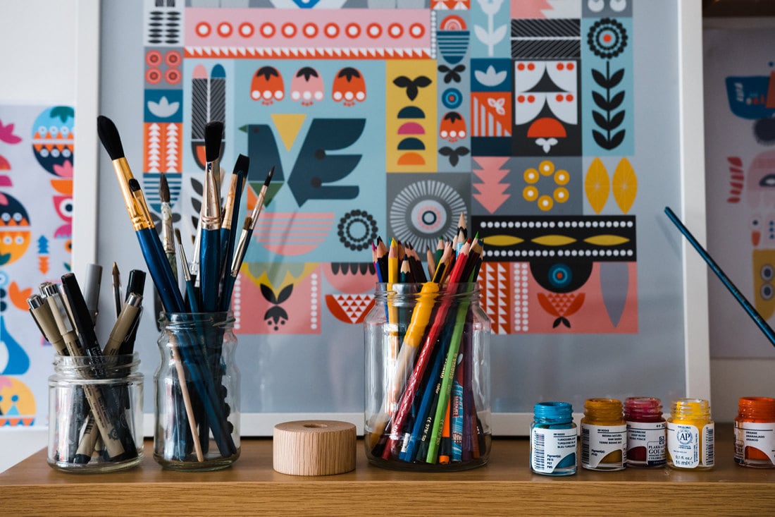 Tatiana's neatly organized supply shelf, stocked with colorful pencils, pens, brushes, and paints