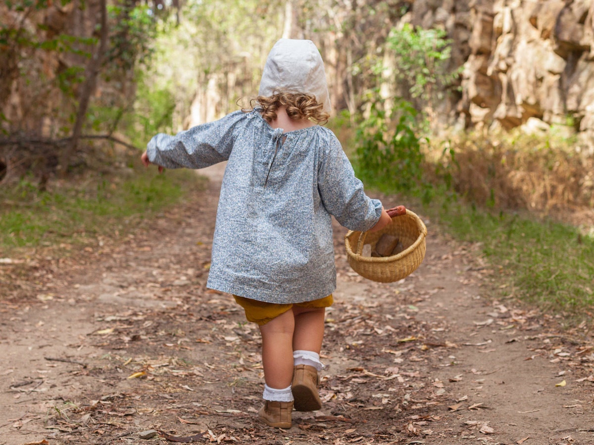 Child at play wearing an écolier kids smock and bonnet