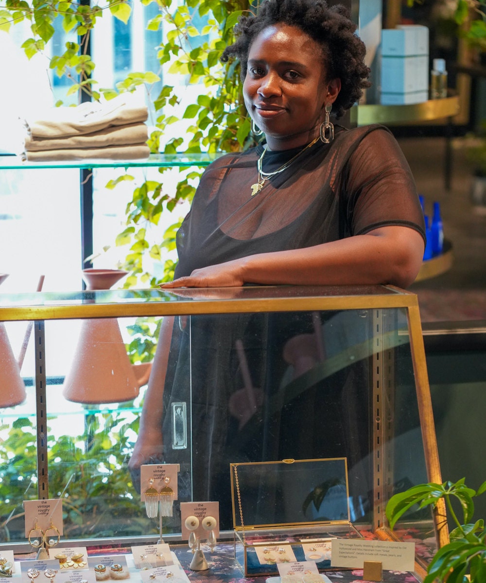 Meena standing behind her earrings display at a local market