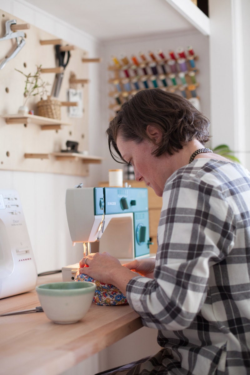 Madeline Bell sewing at her workbench