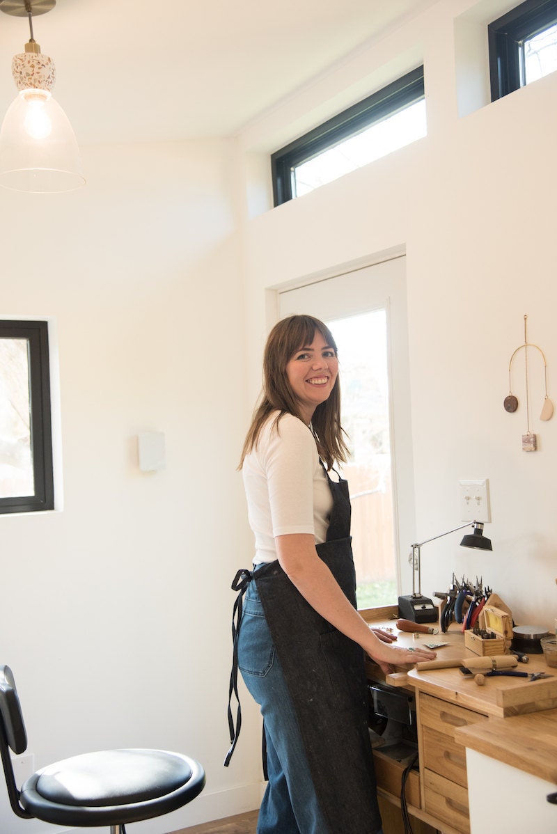 Sarah standing at her desk in her studio