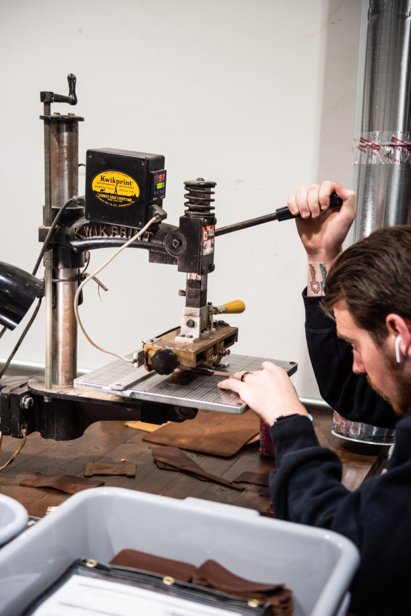 A Holtz Leather Co. employee stamps customization onto leather.