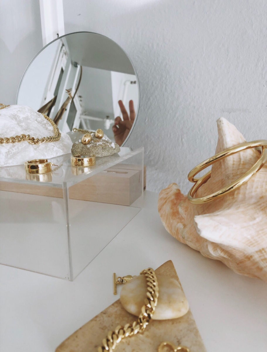 An assortment of gold earrings, necklaces, and bracelets from the Foe & Dear collection