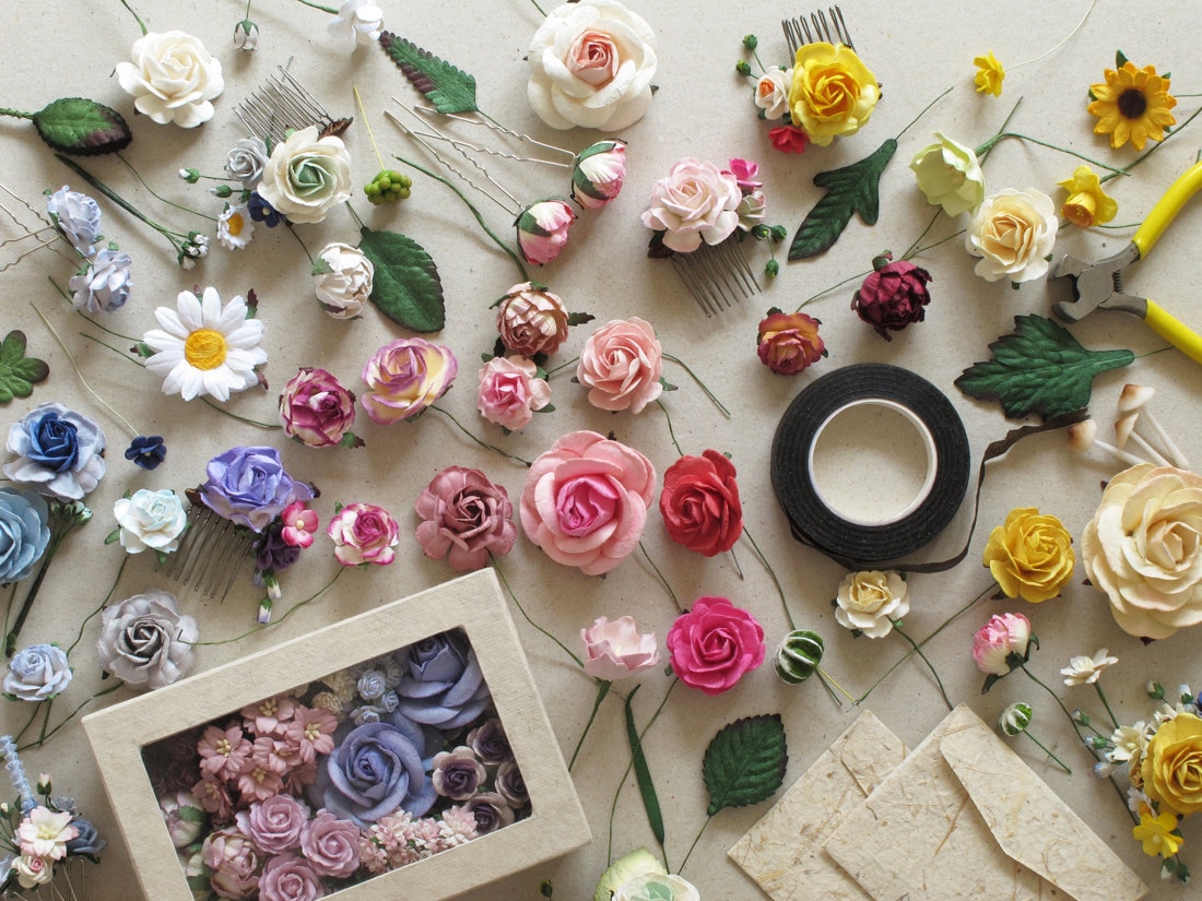 A mix of paper flowers and finished hairpieces organized neatly pre-packaging