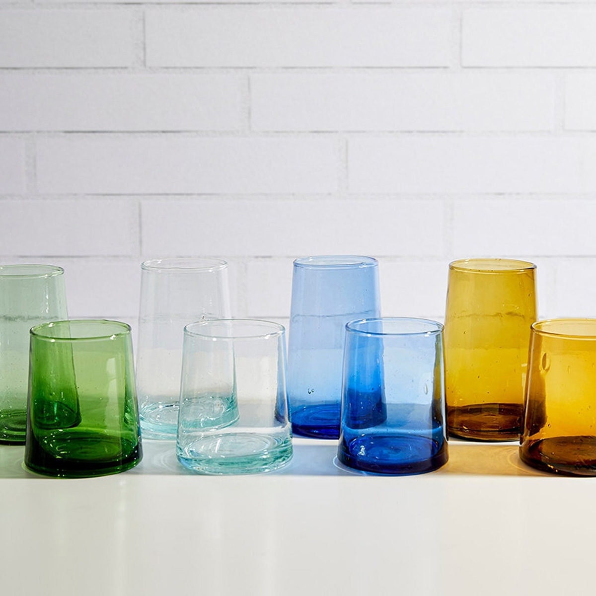 Eight glasses in green, clear, blue, and amber