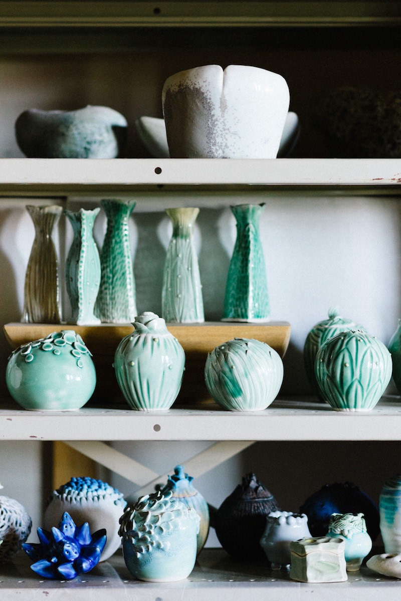 Finishes vessels and vases from Echo of Nature sit on a shelf in Yumiko's studio