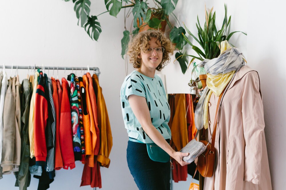 A portrait of handbag designer Alex Bender posing with her bags.