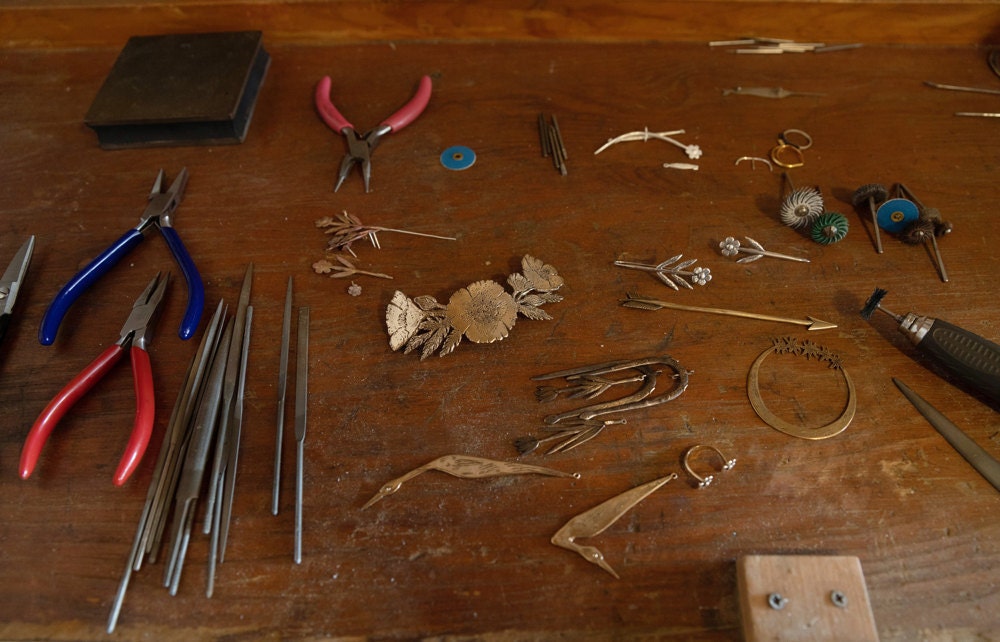 Jieun's workbench scattered with unfinished pieces and jewelry-making tools