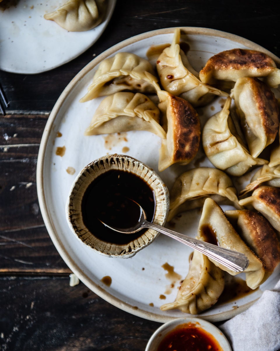Completed dumplings and a bowl of dipping sauce Completed dumplings and a bowl of dipping sauce