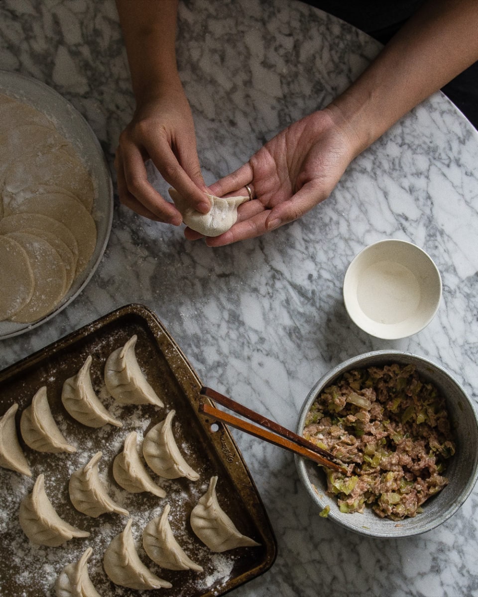 Shaping the filled dough into dumplings