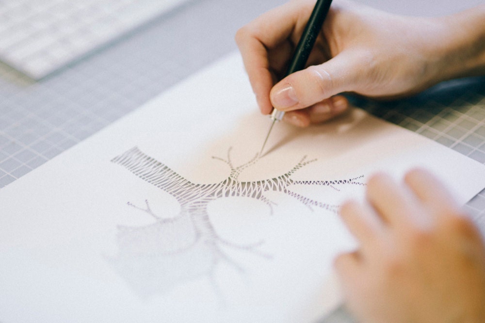 Ali hand-cuts a set of lungs out of paper.