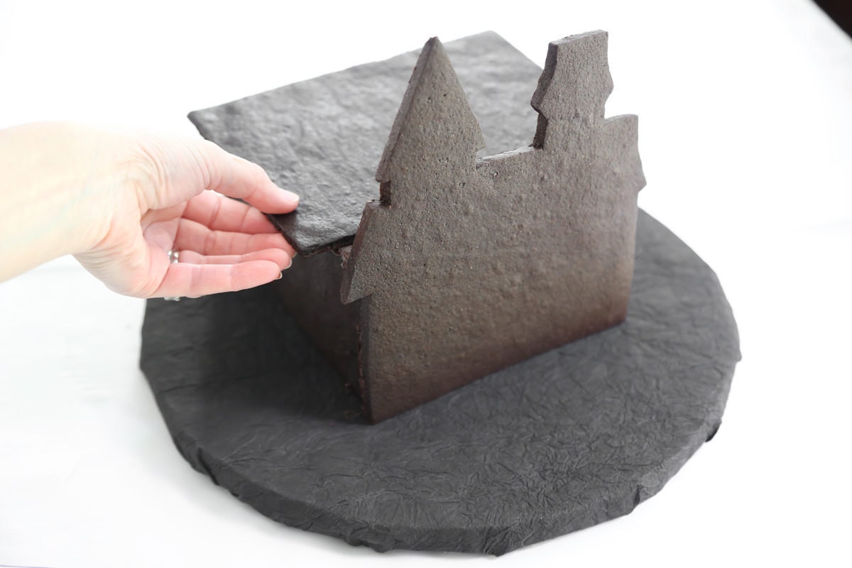 Assembling the castle using melted chocolate to bind the walls together.