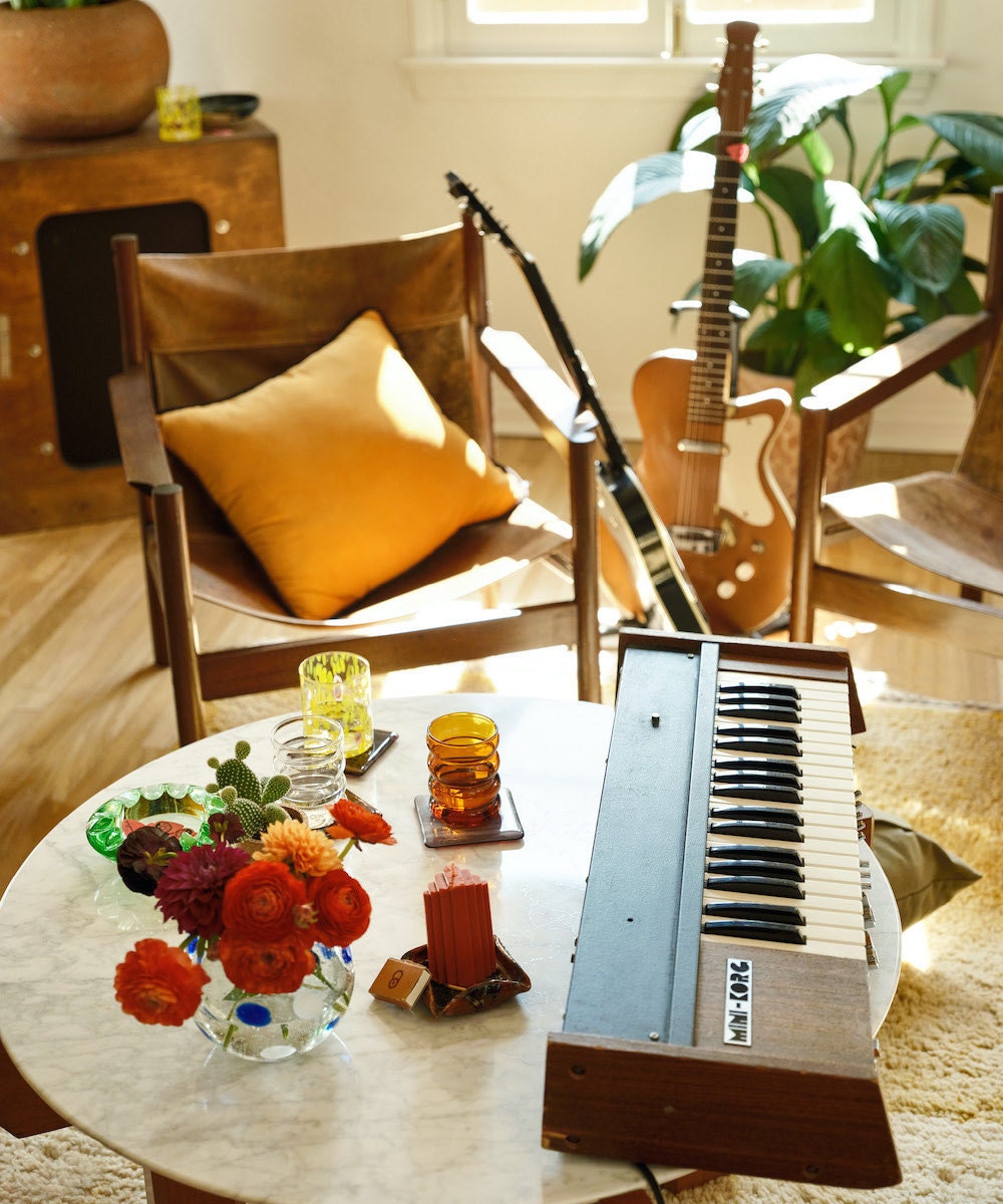 A styled corner of HAIM's home studio, featuring a vintage leather slingback chair from Good Wilson on Etsy.