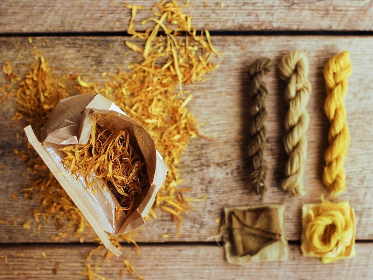 Bag of osage wood chips photographed alongside natural-died yarn skeins