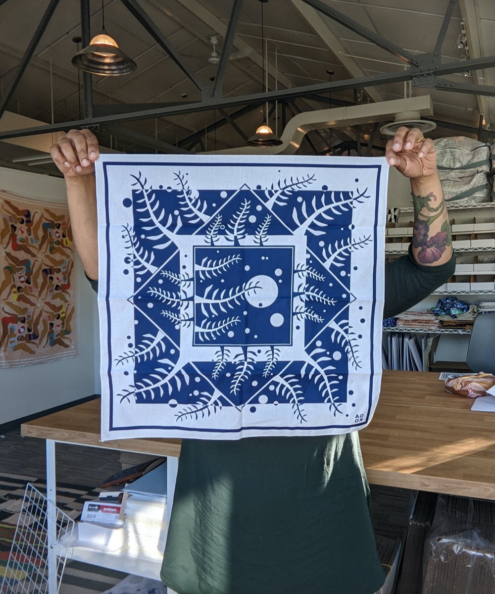 Ama holds up one of her bandana designs, the Navy Forest bandana.