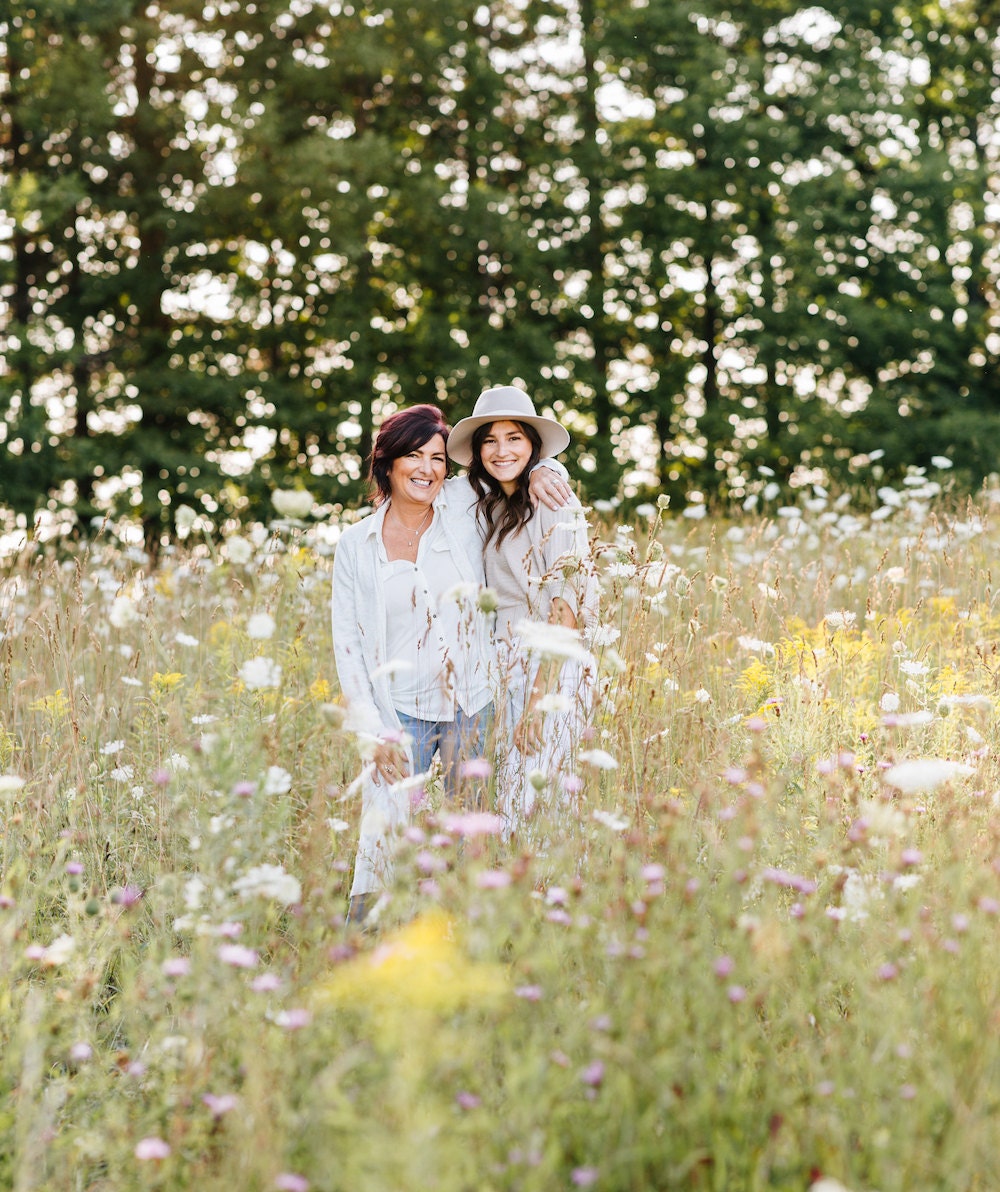 Lynne and Tristan outside in a field of flowers