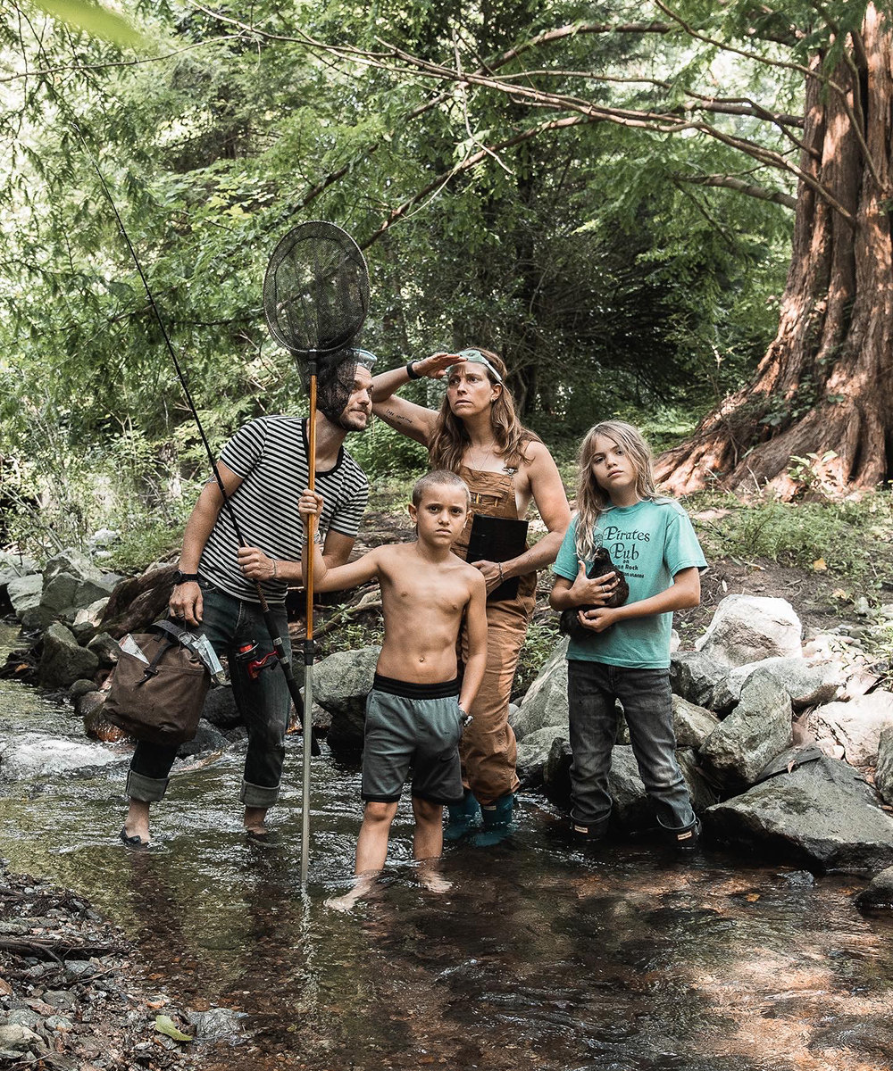 Family portrait of Peg and Awl owners Margaux and Walter Kent and their two children posing playfully out in nature.