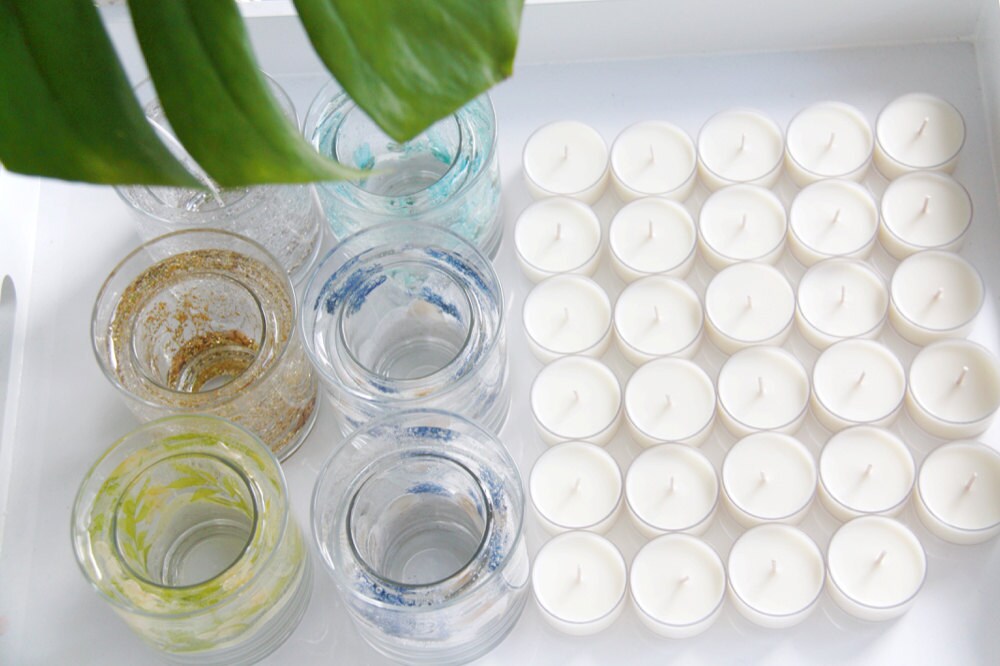 Soy wax tea light candles lined up to be added to decorative glass jars.