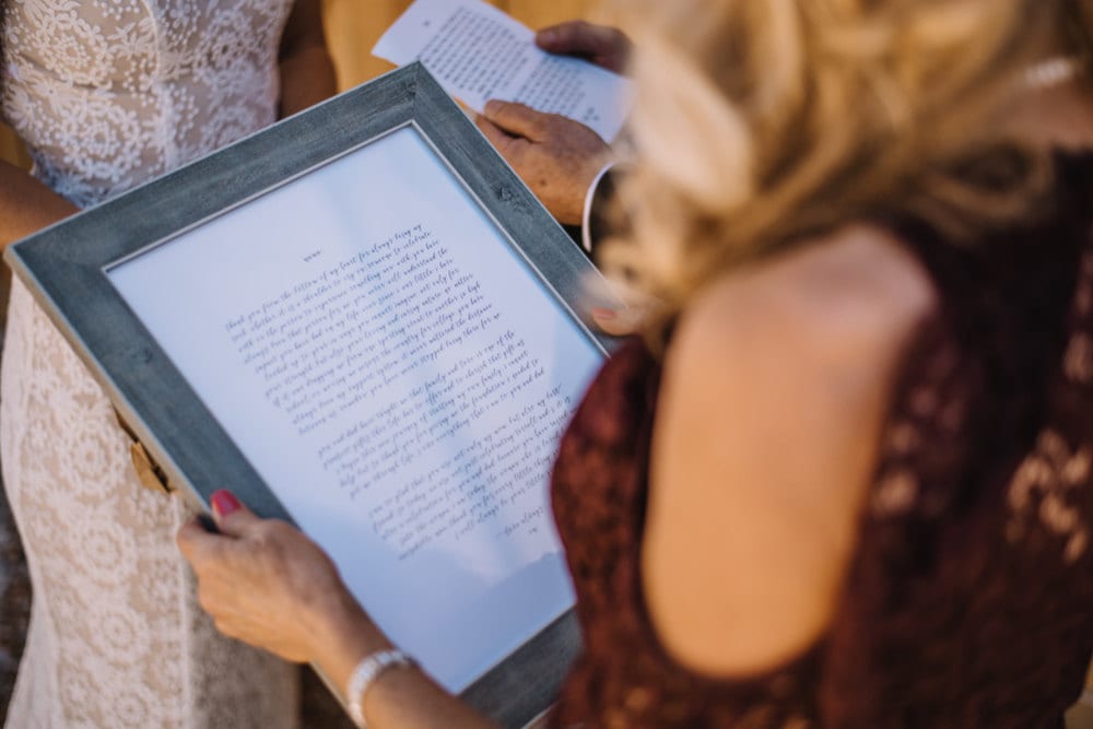 Emily's mother reads a framed, hand-lettered note that Emily presented her as a gift during her first look