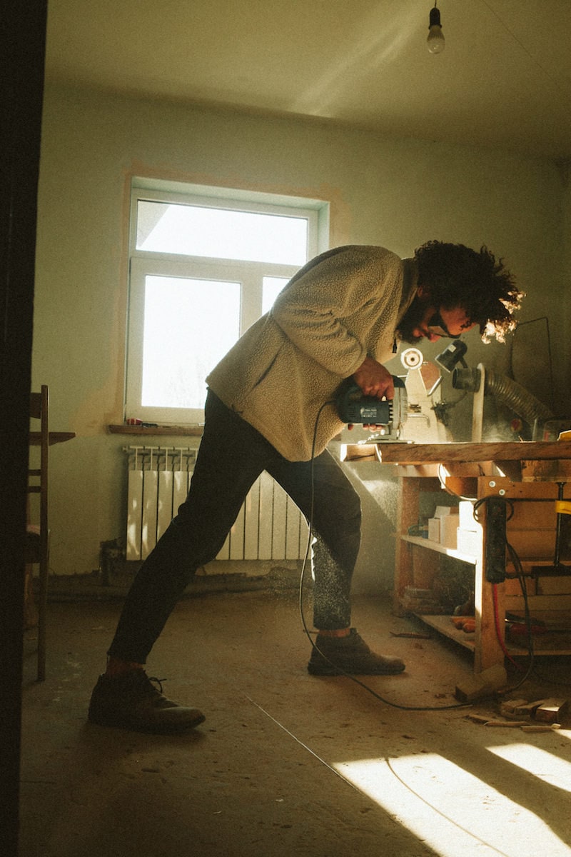 Kirill sanding a piece of wood in his studio