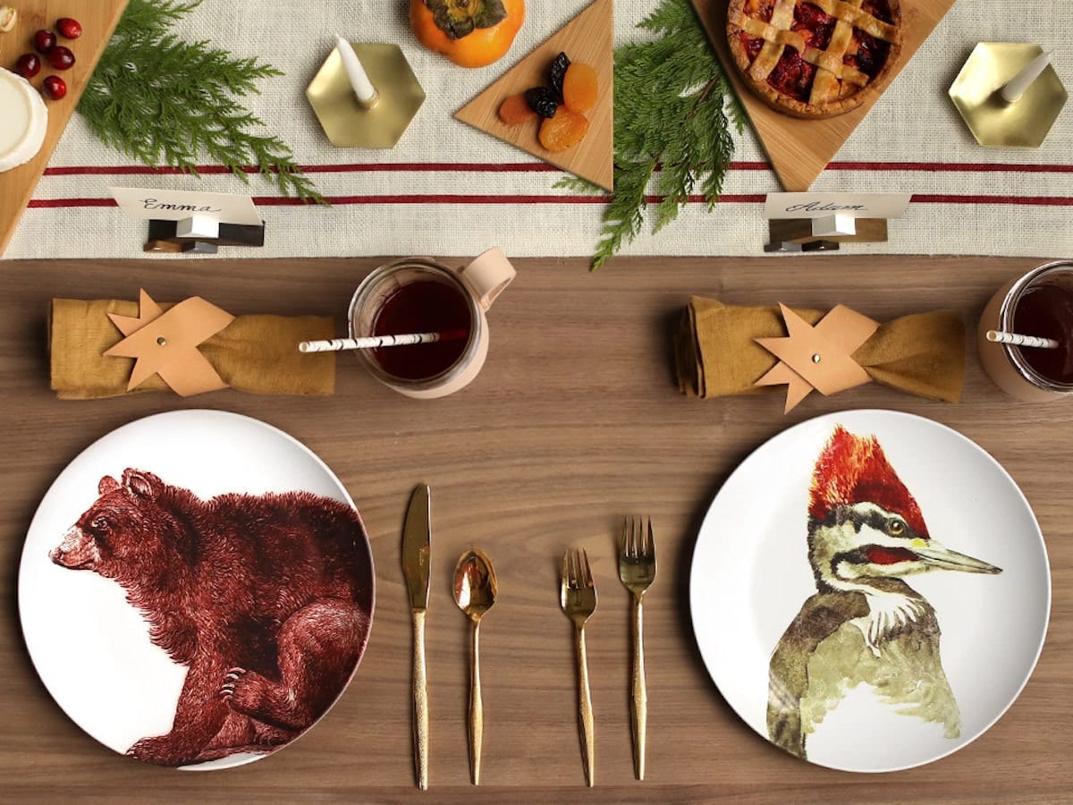 A festive woodland-themed tablescape set with animal plates.