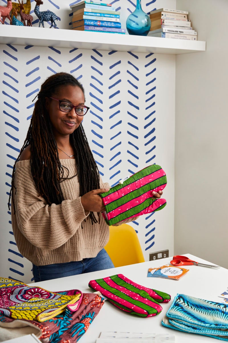 A portrait of Natalie holding up one of her finished oven mitts