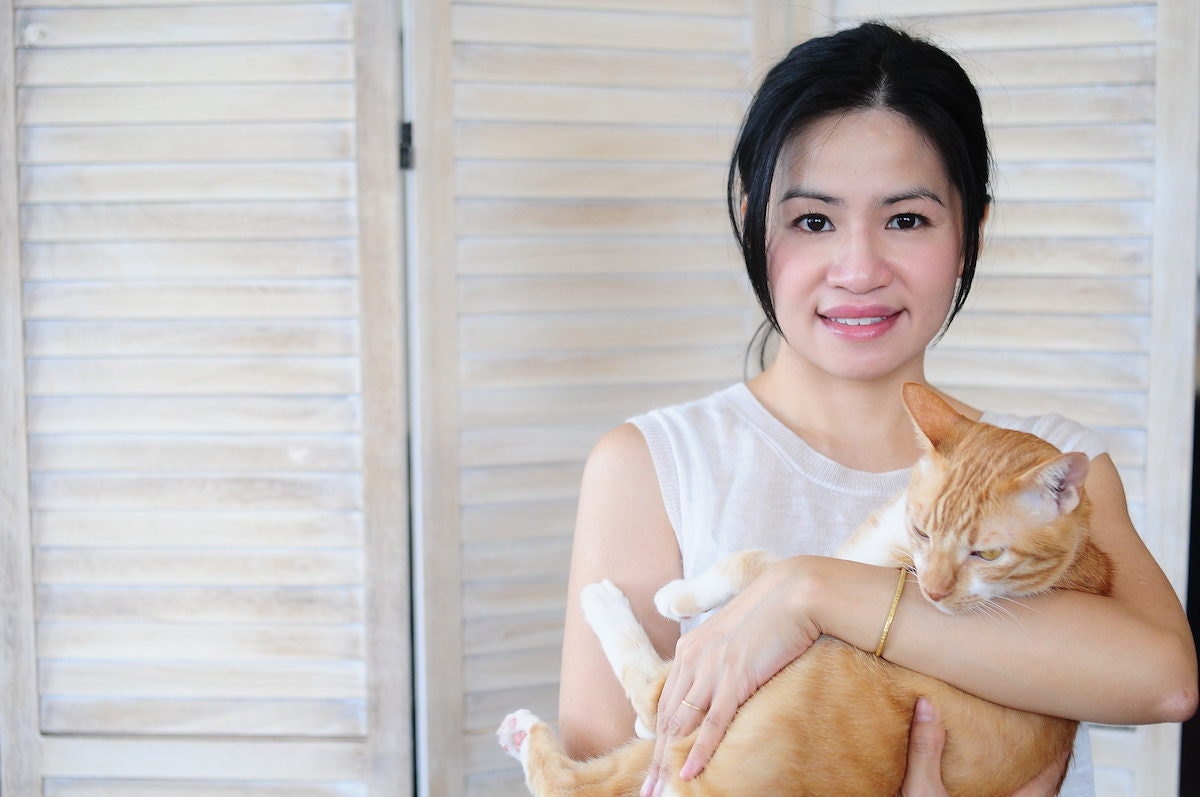 Designer Joe Wong of Artemis Leatherware holding her cat, Yoshi