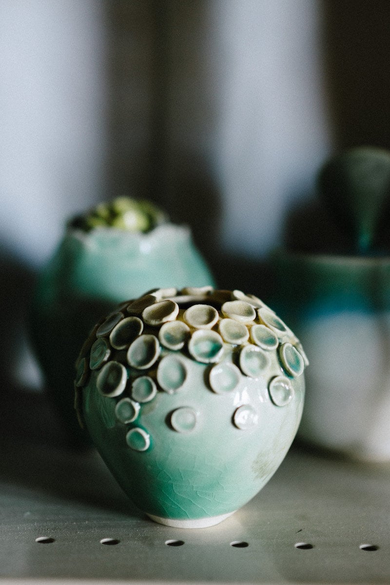 A finished vase sits on a shelf