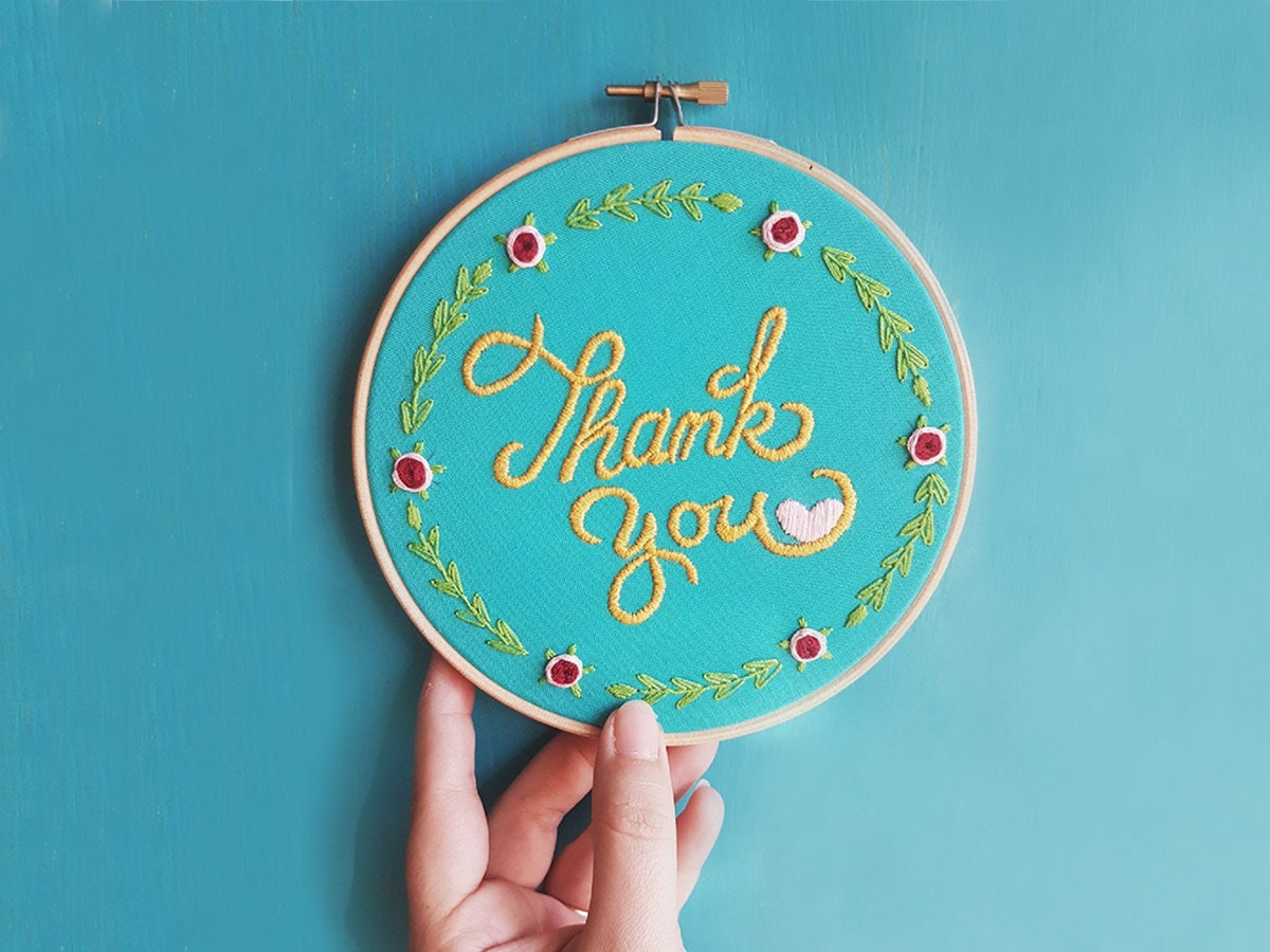 An embroidery hoop stitched with the words