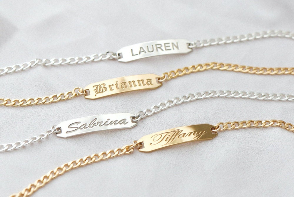 Assorted gold and silver bar bracelets personalized with names, from EVREN.