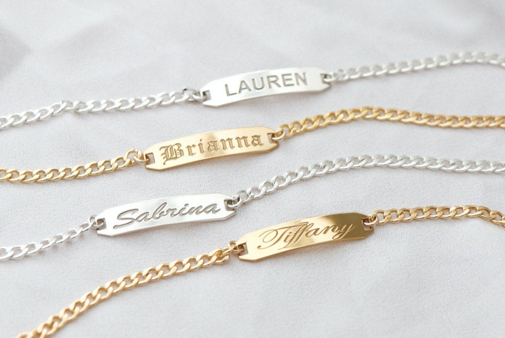 Assorted gold and silver bar bracelets personalized with names, from EVREN.