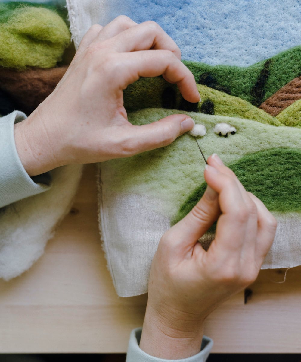 Elizabeth needle felts sheep onto one of her landscape kits.