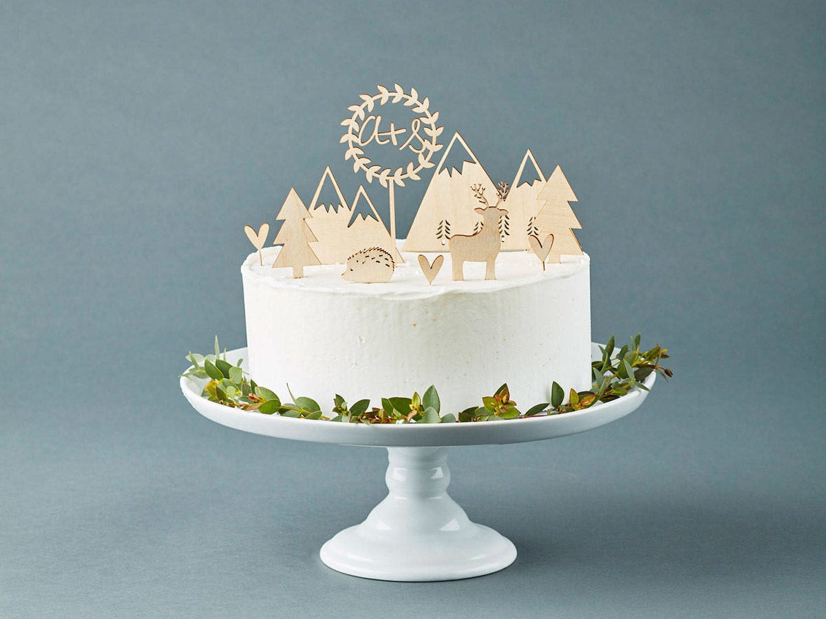 Rustic wooden laser cut cake toppers from Light + Paper displayed on a white wedding cake