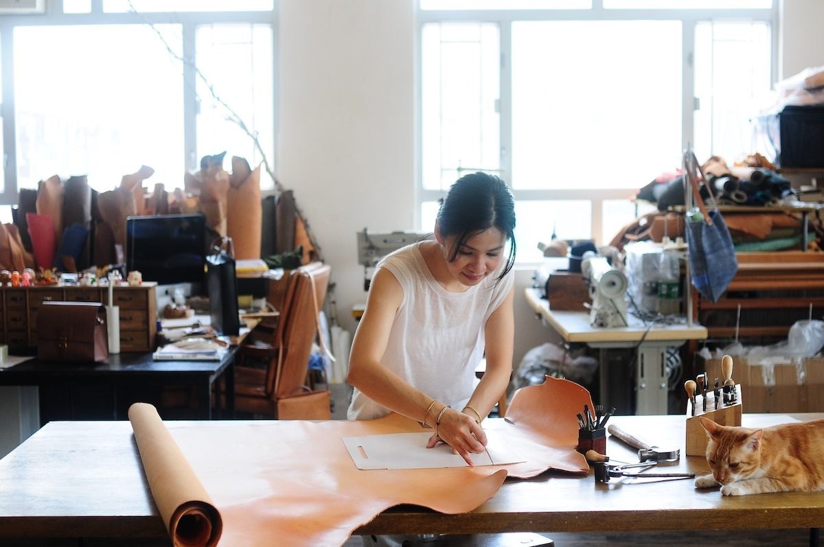 Joe measuring leather in her studio