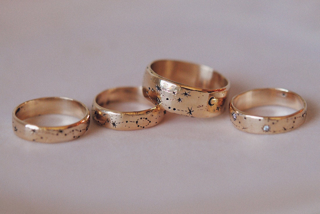 A collection of gold ring bands hand-engraved with constellations from Sofia Zakia