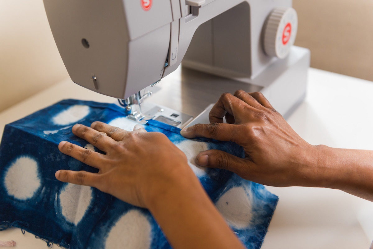 Rajni sews a piece of indigo dyed fabric using a sewing machine