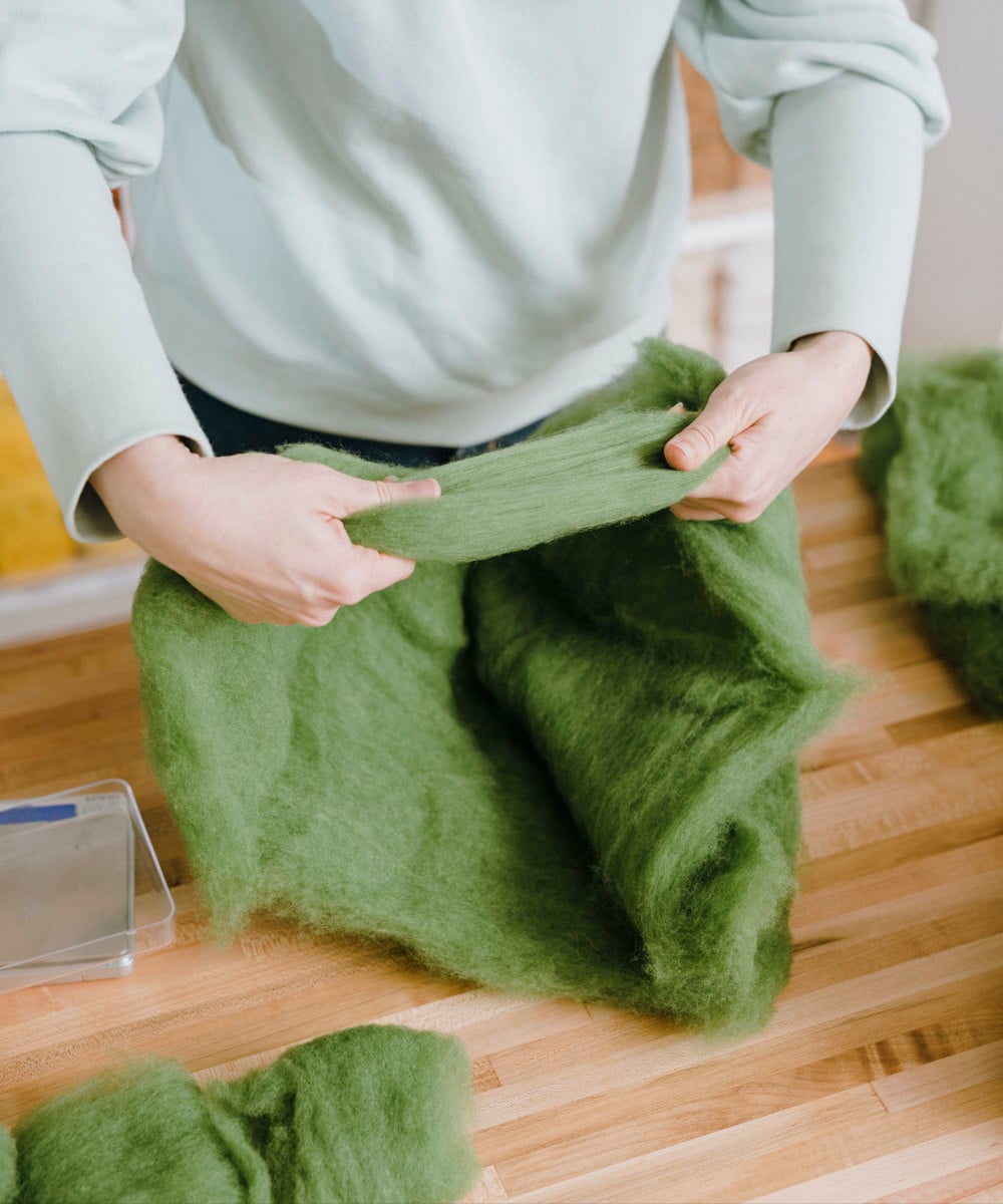 Elizabeth creating a skein of green wool.