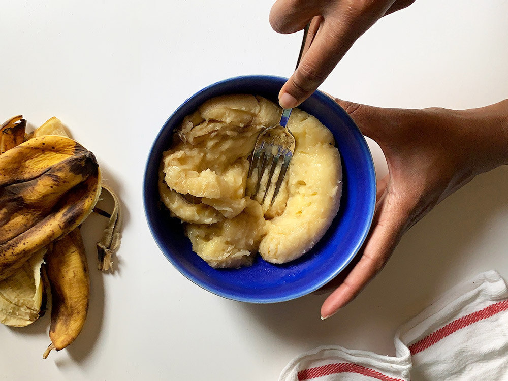 Aravis mashing bananas with a fork.