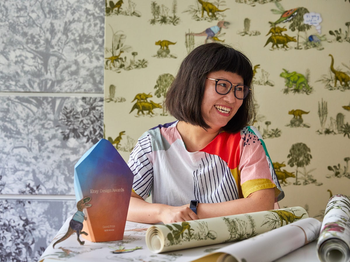 Portrait of Etsy Design Awards Grand Prize Winner Sian Zeng in front of her interactive magnetic dinosaur wallpaper